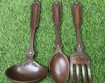 Conjunto de utensílios de parede vintage Arnels em cerâmica, tamanho grande, composto por colher, garfo e concha, na cor marrom.