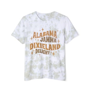 May include: White t-shirt with a tie-dye pattern in shades of green and white. The shirt features the words "ALABAMA JAMMA DIXIELAND DELIGHT" in a retro font with star accents. A casual and comfortable tee.