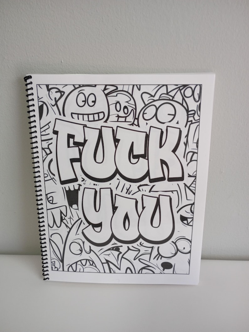 May include: Spiral-bound sketchbook with a black and white doodle art design. The words "FUCK YOU" are prominently displayed in bold, bubble letters. The background is filled with cartoonish faces and shapes.