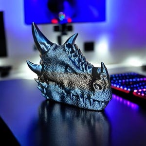 Gamer-style 3D printed dragon head with glossy blue finish, styled on RGB-lit desk.