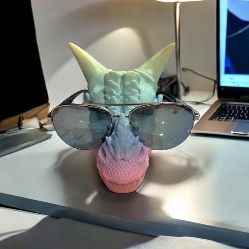 Multicolor dragon glasses holder on desk, fantasy organizer with phone slot and tray.