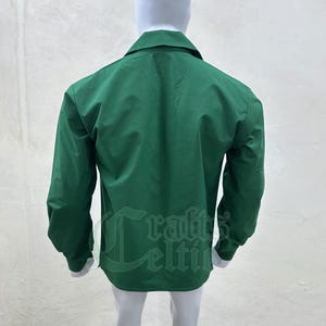 Pu&ograve; includere: Una camicia a maniche lunghe di colore verde scuro con colletto abbottonato.