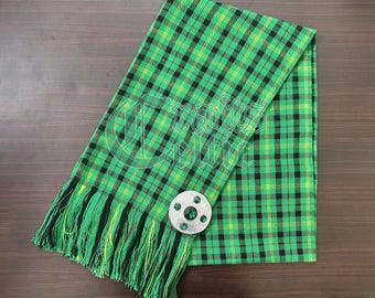 May include: A green and black plaid kilt with a green and silver kilt pin. The kilt has a fringe on the bottom.