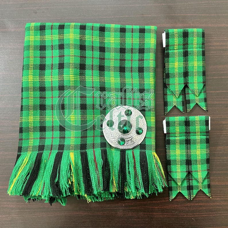 May include: A green, black, and yellow tartan kilt with a silver and green jeweled kilt pin. The kilt has a fringe around the bottom. Two matching green, black, and yellow tartan kilt hose are included.
