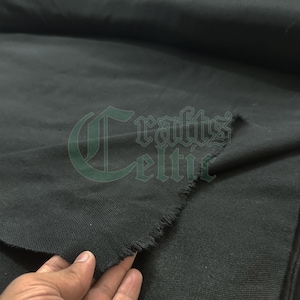 Op de afbeelding: Close-up van een donkergrijze stof met een ruwe, onafgewerkte rand. De stof is gevouwen, wat textuur en diepte laat zien. Het logo "Crafts Celtic" is zichtbaar in de linkerbovenhoek.