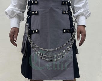 May include: A grey and black kilt with silver chain detailing. The kilt features a grey front panel with black accents and silver hardware. The design includes a pleated skirt and decorative chains. The kilt is a traditional garment.