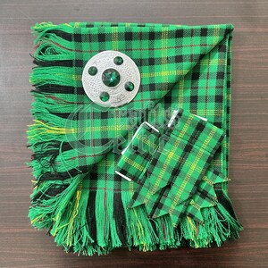 May include: A green, black, and red tartan kilt with a silver and green kilt pin. The kilt is fringed and has a matching kilt hose.