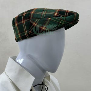 May include: A green, red, and yellow plaid flat cap with a slightly curved brim.