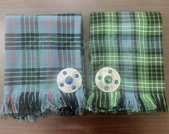 May include: Two kilt sashes with fringe, one blue and one green, each with a silver kilt pin with a blue or green gem in the center.