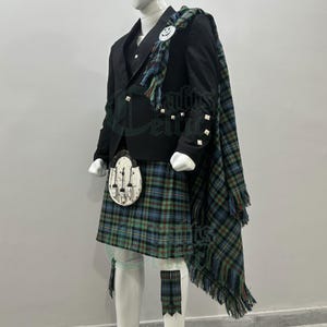 May include: A formal Scottish kilt outfit displayed on a mannequin. The outfit features a black jacket, vest, and a tartan kilt in green, blue, and black. A matching tartan sash and sporran are also included. The mannequin is white.