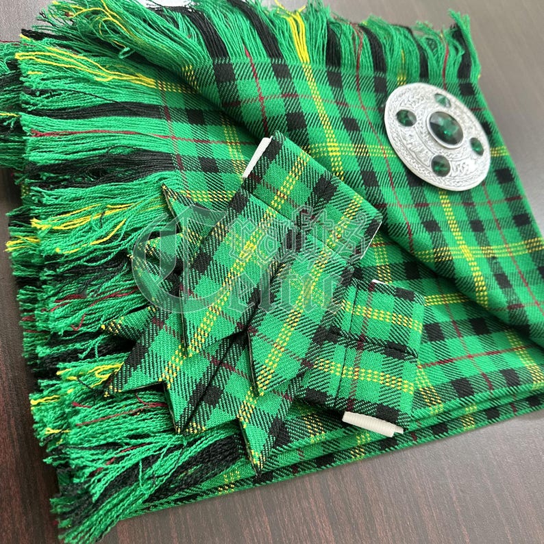 May include: A green, black, and yellow tartan kilt with a matching sash and a silver kilt pin with a green stone.