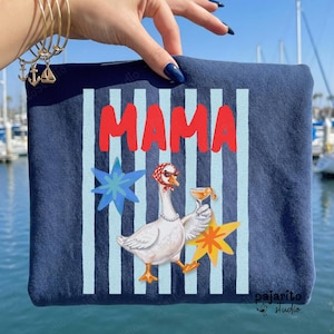 Puede incluir: Sudadera azul marino con la palabra "MAMA" en letras rojas. El diseño presenta un ganso con pañuelo y gafas de sol, sosteniendo un cóctel, con estrellas y rayas. El logotipo "pajarito studio" está en la esquina inferior derecha.