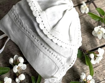 Gorro vintage de algodón blanco para bebé con encaje intrincado y lazos de cinta de satén
