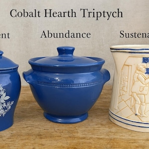Pode incluir: Um conjunto de cerâmica tríptico azul cobalto. O conjunto inclui um pote com tampa e design floral, uma tigela com tampa e um jarro com alça. O jarro tem um fundo creme com um design azul e branco.