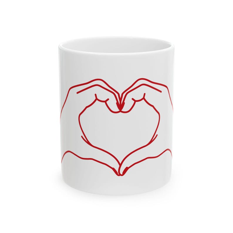May include: White ceramic mug with a red outline of two hands forming a heart shape.