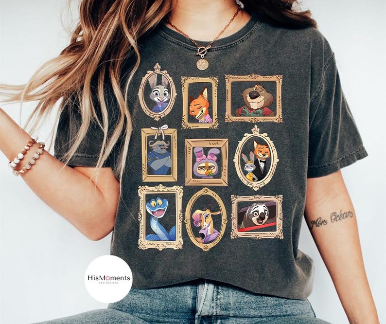 Puede incluir: Camiseta gris oscuro con retratos enmarcados de personajes de animales animados. Los retratos est&aacute;n en marcos dorados e incluyen un conejo, un zorro y un perezoso. La camiseta tiene un lavado vintage.