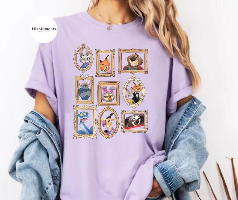 Puede incluir: Una camiseta lila con retratos de animales de dibujos animados enmarcados. Los retratos incluyen un conejo, un zorro, un oso y otros personajes. La camiseta tiene mangas cortas y un corte holgado. El logotipo de la marca "HisMoments" est&aacute; en la esquina superior izquierda.