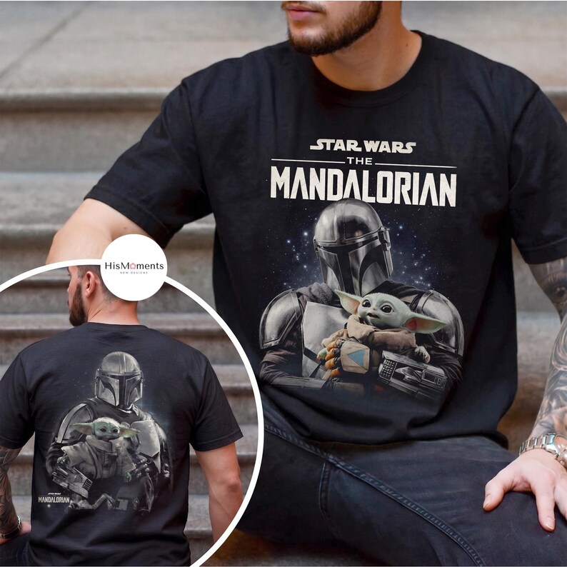 May include: Black t-shirt featuring a graphic of The Mandalorian and Grogu from Star Wars. The front of the shirt displays the show's title and a detailed image of the characters. The back of the shirt also has the same image.