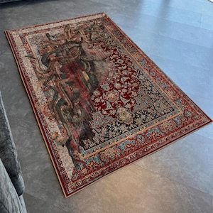 May include: A red, blue and green patterned rug with a large, faded, abstract design in the centre. The rug has a traditional Persian style border.