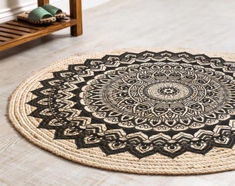 May include: A round jute rug with a black and white mandala design. The rug has a natural, woven texture.