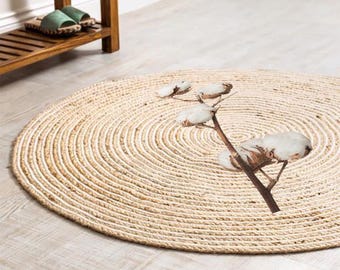 Puede incluir: Una alfombra redonda de fibra natural con un patrón circular y un diseño de flor de algodón en el centro.