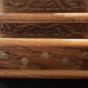 Puede incluir: Dos cajas de madera con intrincados tallados y detalles en pan de oro. Las cajas están apiladas una encima de la otra.