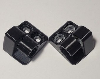 May include: Two black plastic hinges with three holes each. The hinges are designed to be used for attaching two pieces of material together.