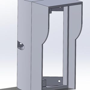 Può includere: Un alloggiamento in metallo grigio per una telecamera per citofono. L'alloggiamento ha una forma rettangolare con una parte superiore e inferiore arrotondate. Ci sono diversi fori nell'alloggiamento per il montaggio e il cablaggio.