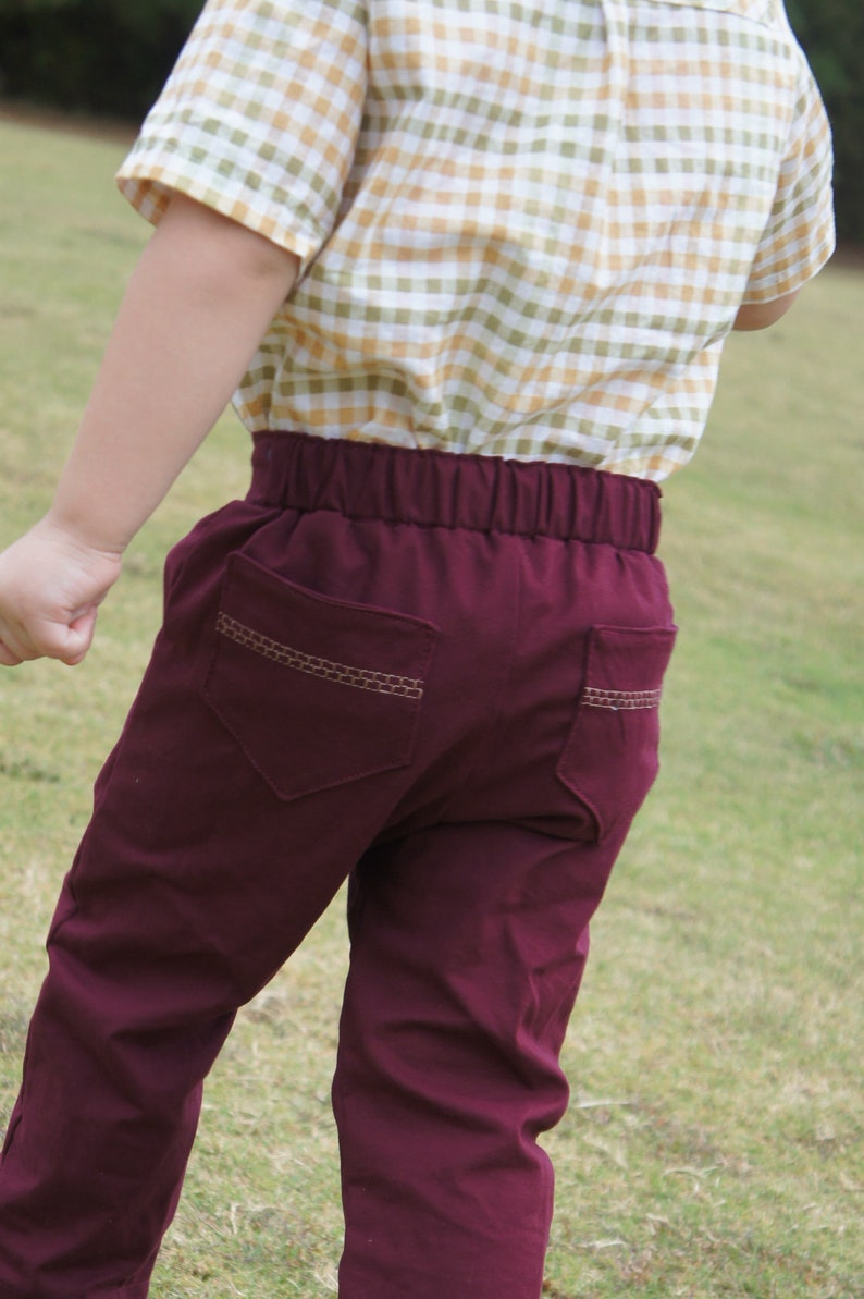 Op de afbeelding: Bordeaux broek met een bruin gestikt zakdetail. De broek heeft een elastische tailleband.