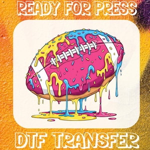 May include: A digital DTF transfer design featuring a pink donut shaped like a football, with yellow and blue icing dripping down. The design includes the text "READY FOR PRESS" at the top and "DTF TRANSFER" at the bottom.