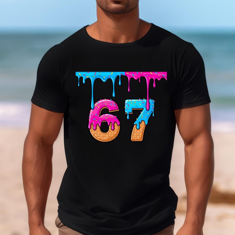 May include: Black t-shirt featuring the number "67" in a playful, cartoonish style. The numbers are designed to resemble donuts, with pink and blue icing dripping down. The shirt has a crew neck and short sleeves.