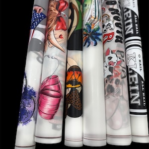 May include: A collection of six white cylindrical objects with various colorful designs. The designs include an American flag, a pig with a lei, and text that reads "ALL HAIL KEITH". The objects are arranged vertically against a black background.