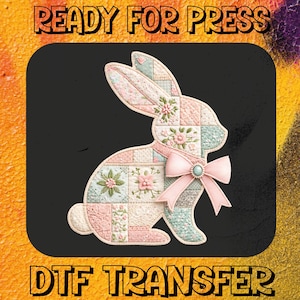 May include: A pastel patchwork bunny design with floral details and a pink bow, with the text "READY FOR PRESS" and "DTF TRANSFER". The bunny is set against a black background with a colourful, textured border. Ideal for DTF transfers.