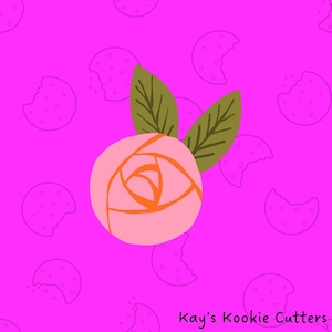 May include: A pink rose with orange details and two green leaves, set against a bright pink background with cookie outlines. The text "Kay's Kookie Cutters" is in the bottom right corner.