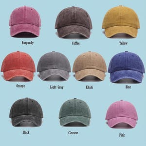 May include: Nine baseball caps in various colors, including burgundy, coffee, yellow, orange, light gray, khaki, blue, black, green, and pink. Each cap has a curved brim and a fabric strap closure. The colors are labeled below each cap.
