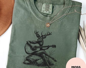 Maglietta con cervo che suona la chitarra - Comfort Color® - Maglietta rustica per festival folk, maglietta per amanti della musica acustica indie, regalo per musicisti all'aperto, maglietta country