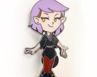 Op de afbeelding: Een cartoonfiguur met paars haar, gele ogen en een zwart en rode outfit. Het personage glimlacht en heeft een vriendelijke uitdrukking. Dit is een metalen emaille pin.