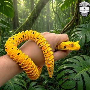 May include: A bright yellow articulated snake toy with black spots and orange accents. The snake features a segmented, flexible body design that wraps around the wrist, with a detailed head showing prominent eyes and small horn-like protrusions.