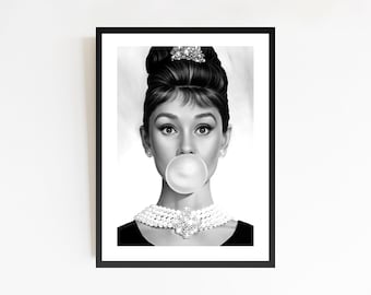 May include: Black and white framed print featuring a portrait of a woman with dark hair styled in a bun, blowing a bubble. She wears a pearl necklace and earrings. The image is a pop art style interpretation.