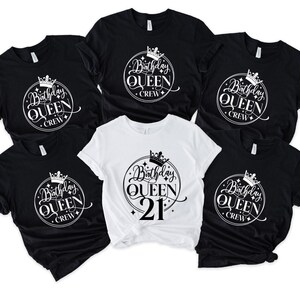 Op de afbeelding: Een verzameling zwarte en witte t-shirts. De shirts hebben een cirkelvormige afbeelding met een kroon, de woorden "Birthday Queen" en "Crew". Eén shirt heeft "21" onder de tekst. De shirts zijn korte mouwen.