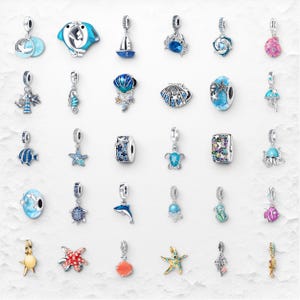 Può includere: Una collezione di ciondoli in argento con disegni a tema oceanico. I ciondoli includono un delfino, una stella marina, un cavalluccio marino, una tartaruga e un granchio. I ciondoli sono in vari colori, tra cui blu, argento e oro. I ciondoli sono progettati per essere utilizzati su un braccialetto o una collana.