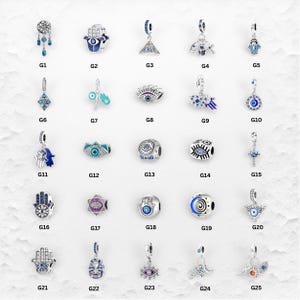 May include: A collection of silver charms with various designs, including Hamsa hands, evil eyes, and celestial motifs. The charms feature blue, silver, and other colorful accents. These charms are suitable for bracelets and necklaces.
