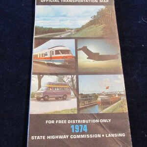 May include: A vintage Michigan Great Lake State Official Transportation Map from 1974. The cover features images of a train, plane, van, and boats. The map is for free distribution and was published by the State Highway Commission in Lansing.