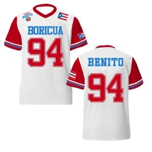 Pode incluir: Camisola branca com mangas e detalhes vermelhos. A frente exibe "BORICUA" em azul, o número "94" em vermelho e uma bandeira de Porto Rico. A parte de trás mostra "BENITO" e o número "94". A camisola tem decote em V e um pequeno logótipo "TEAM BENITO".