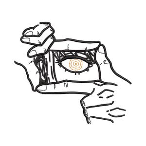 Könnte beinhalten: Schwarz-weiß gesticktes Design mit einem Auge, das von Händen umrahmt wird. Das Auge hat detaillierte Wimpern und eine goldene Iris mit konzentrischen Kreisen. Das Design befindet sich auf weißem Hintergrund, geeignet für Kleidung oder Accessoires.