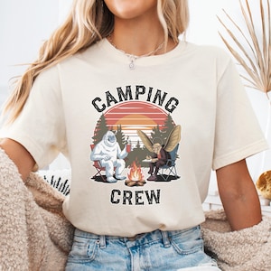 Camiseta de equipo de acampada, divertida camiseta de acampada con Yeti y Mothman, camiseta de atardecer con incendio forestal críptico, camiseta de amigos de la hoguera al aire libre, camiseta para amantes de Pie Grande