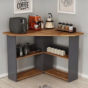 Op de afbeelding: Een hoekkast met een houten blad en grijze steunen. Het heeft planken met diverse keukenapparatuur, waaronder een koffiezetapparaat, een airfryer en een waterkoker. De kast bevat ook kruidenpotjes en andere keukengereedschappen.