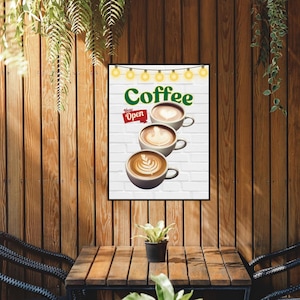 May include: A white sign with the words "Coffee" and "Now Open" in green and red text. Three cups of coffee with latte art are stacked on top of each other. The sign is hanging on a wooden wall.