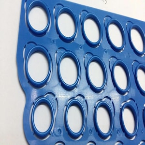 May include: A blue plastic sizing guide with multiple oval openings. Each opening has a size marking, ranging from 4 1/2 to 6. The guide is designed to measure ring sizes, with the ovals representing different ring diameters.