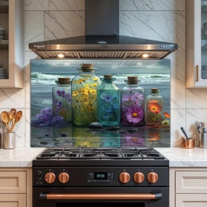 以下が含まれることがあります： カラフルな花で満たされたガラス瓶のある海岸のシーンを描いた、装飾的なキッチンのスプラッシュバック。瓶は、嵐の空のある海の風景の前に配置されています。スプラッシュバックは黒いコンロの上に設置されています。